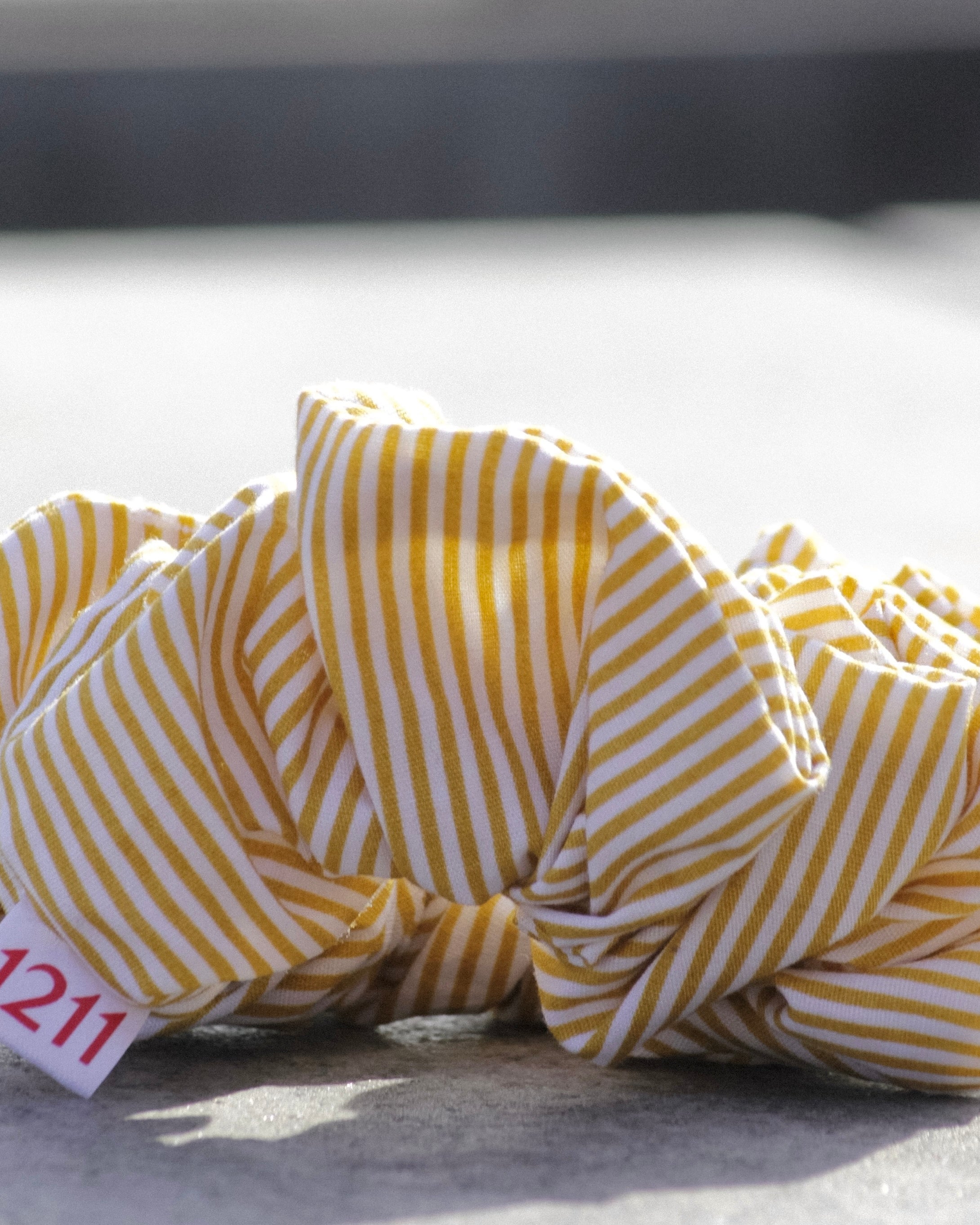 Yellow scrunchie with white stripes, elegant hair accessory from Twelveeleven, perfect for everyday styling.
