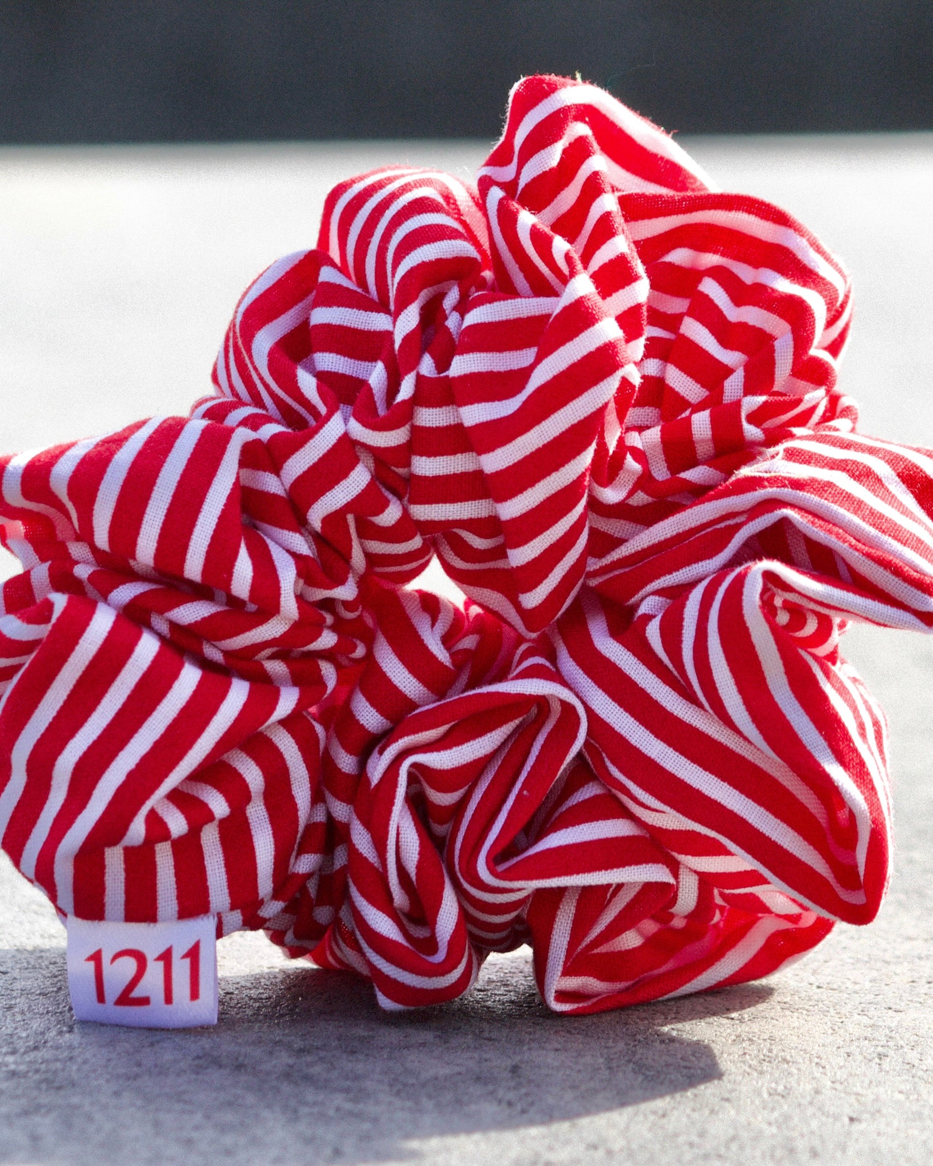 Red scrunchie with white stripes, elegant hair accessory from Twelveeleven, perfect for everyday styling.